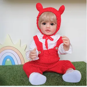 55cm lifelike reborn baby doll Betty wearing a red knitted outfit on a lawn