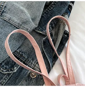 Gros plan d'une bandoulière en cuir PU rose avec surpiqûres sur un sac de style japonais