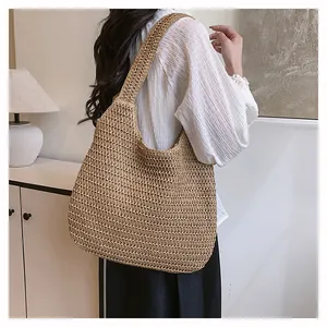 Lifestyle shot of a woven straw tote bag for women in natural khaki bohemian style