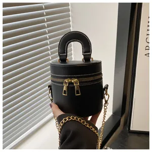 Détail du sac seau en cuir noir avec surpiqûres blanches et double fermeture éclair dorée