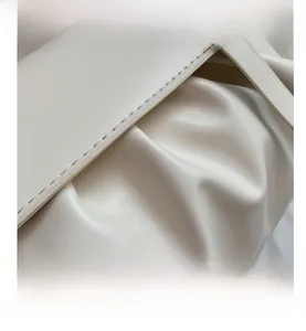 Gros plan sur la texture plissée et les coutures fines d'un sac à bandoulière en cuir