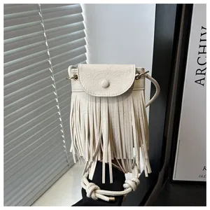 Detail der cremefarbenen Tasseltasche mit gewebtem Trageriemen und Kieseltextur