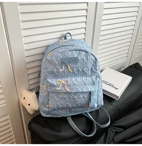 Détail d'un sac à dos matelassé bleu clair avec nœuds pailletés et étoile