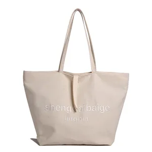 Minimalistische beige große Canvas-Einkaufstasche mit gestickten Textdetails