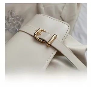 Détails du sac plissé crème avec fine sangle décorative et boucle en métal doré
