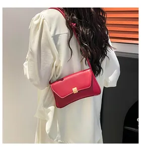 Fashionable red baguette bag with gold buckle worn on the shoulder with white shirt