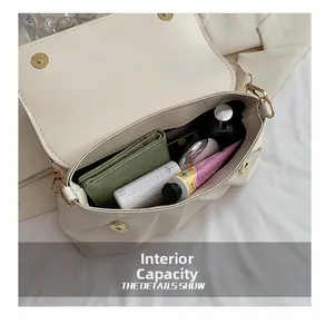 Capacité interne du sac à bandoulière plissé beige avec porte-monnaie et maquillage