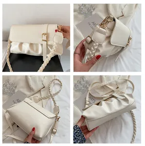 Détail du sac plissé crème en cuir avec boucle dorée et bandoulière tressée