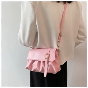 Détail du sac bandoulière plissé rose clair avec boucle dorée et sangle réglable