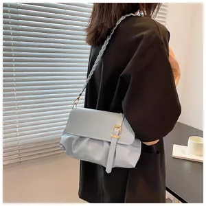 Détail du sac plissé en similicuir bleu clair avec bandoulière tressée et boucle