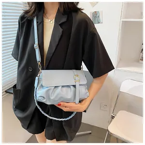 Détail du sac plissé bleu clair avec chaîne tressée et boucle dorée élégante