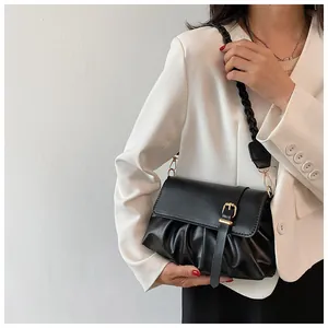 Détail du sac nuage noir plissé avec bandoulière tressée et boucle dorée élégante