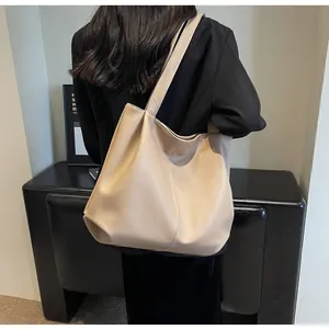Detailed side view of beige large-capacity tote bag showing textured pebbled leather material