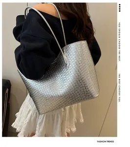 Bolso tote plateado metalizado con textura de rejilla llevado al hombro