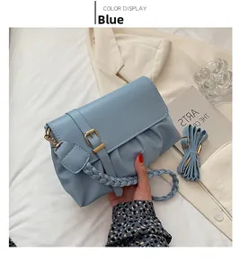 Détail du sac plissé bleu clair avec poignée tressée et boucle dorée décorative