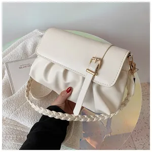 Détail d'un sac à main plissé crème avec poignée tressée et boucle dorée décorative