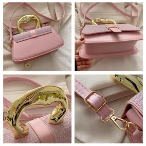 Detail view of pink leather bag featuring glitter flap and unique gold metal handle