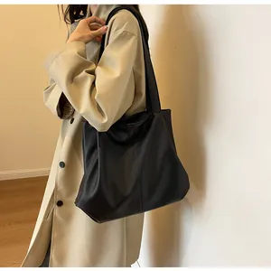 Detail of black pebbled leather tote bag with vertical stitching and large capacity