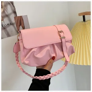 Gros plan sur un sac plissé rose avec poignée tressée et boucle pour femme