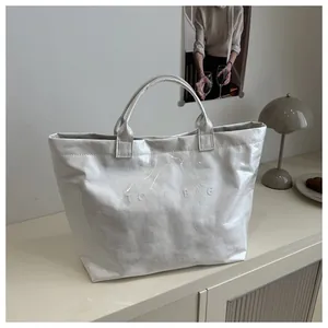 Detalle del bolso tote de papel DuPont blanco impermeable con texto TOTE BAG grabado