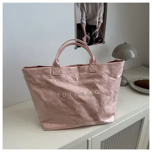 Detalle del bolso tote de papel tyvek rosa con capa de PVC impermeable y estampado