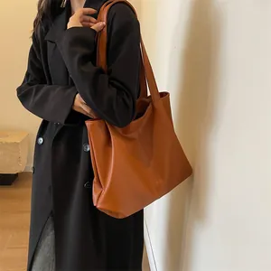 Vintage brown large capacity tote bag worn by a model in a black wool coat