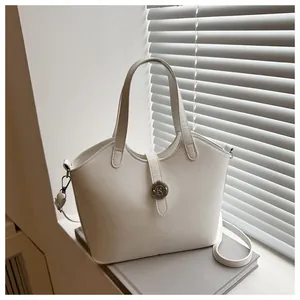 Detail einer weißen Leder-Eimertasche mit N-Metallschnalle und schmalem Schultergurt