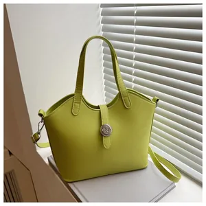 Detailansicht der grasgrünen Leder-Eimertasche mit Logo und verstellbarem Riemen
