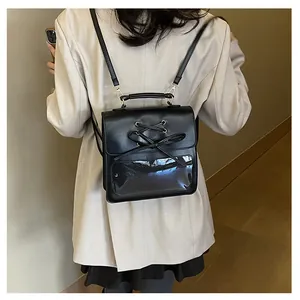 Detail of black PU leather backpack featuring lace-up bow design and clear window display