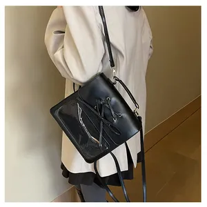 Detail of black stylish handbag with transparent PVC window and lace-up design elements