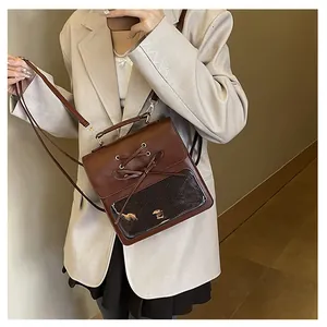 Detail view of brown vintage backpack with ribbon bow and transparent PVC display window