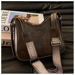 Detailed shot of dark brown retro bucket bag with wide jacquard patterned shoulder strap
