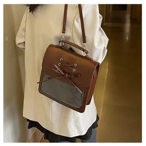 Detail of brown PU leather Ita Bag with transparent PVC window and bow decoration
