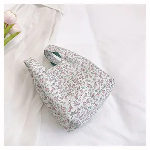 Detail of floral tote bag with green gingham lining and sturdy fabric handles