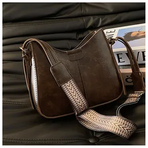 Close-up of retro dark brown leather bucket bag with stylish woven strap detailing