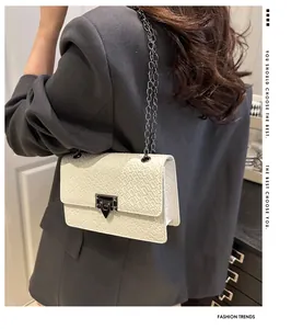 Detailed close-up of a white stone pattern crossbody bag with a dark metal chain strap