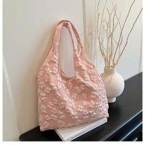 Dettaglio della trama floreale in rilievo 3D sulla superficie della borsa rosa