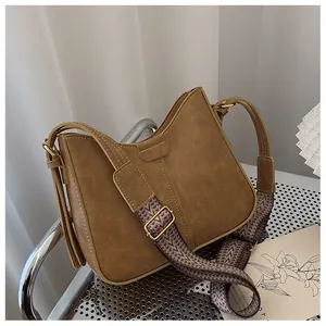 Detail of vintage brown shoulder bag with textured leather and woven jacquard strap