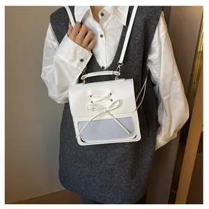 Close-up of white PU leather crossbody bag with bow detail and mesh compartment