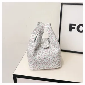 Detailed view of floral canvas tote with white lace trim and blue pink flower pattern