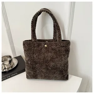Detail of dark brown chenille tote bag featuring rich woven texture and gold metal buckle