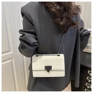 Detalle de la textura tejida blanca y el cierre de metal gris oscuro del bolso cuadrado