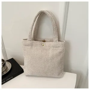 Detailed macro view of the cream corduroy tote bag with golden magnetic snap closure