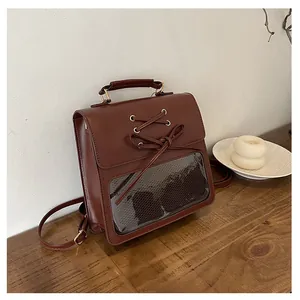 Macro detail of vintage brown faux leather backpack with clear PVC window and bow decor
