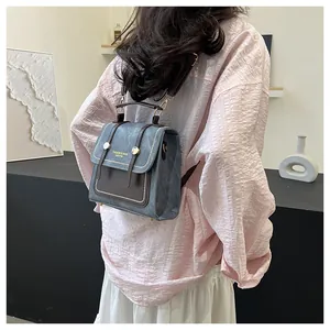 Détail d'un sac à dos vintage bleu-gris avec lanières marron et boucle en métal