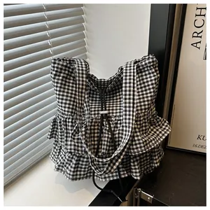 Detail of checkered tote bag with lace ruffle edges and drawstring closure