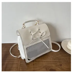 Close-up of white PU leather backpack featuring ribbon bow and mesh window detail