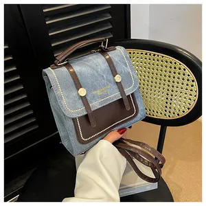 Détail d'un sac à main en denim bleu et cuir marron avec boucle dorée élégante