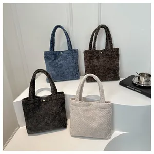 Detail of minimalist woven tote bags in four colors with gold metal buckles and textures