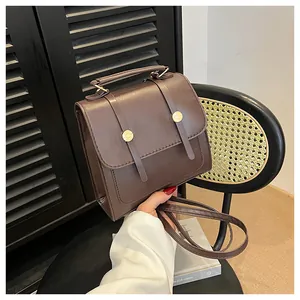 Détails du sac à main marron vintage avec boucles dorées et texture de poignée haute